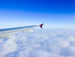 cervical bleeding | Hemophilia News Today | Stock photo of an airplane wing against a blue sky, with a blanket of clouds below.