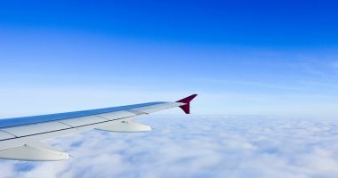 cervical bleeding | Hemophilia News Today | Stock photo of an airplane wing against a blue sky, with a blanket of clouds below.