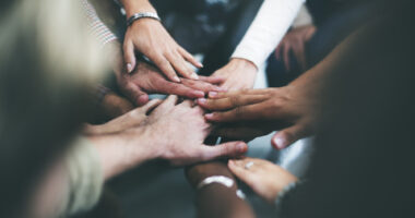 close-up of hands together in solidarity