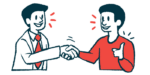 A doctor and patient shake hands while talking with one another.