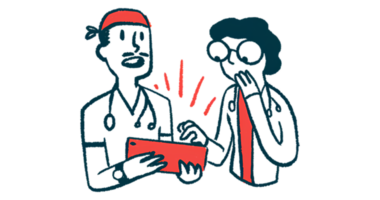 Two doctors look at a tablet computer.