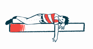 A frowning person lies on a bed with one arm hanging over the edge.