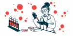 A scientist works with a petri dish in a laboratory alongside a rack of filled vials.