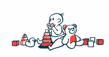 A baby surrounded by toys is mouthing one.