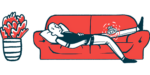 A bald man lies on a couch with an ice pack on his knee.