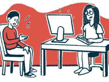 A patient talks to a doctor who is sitting at a desk in front of a computer.